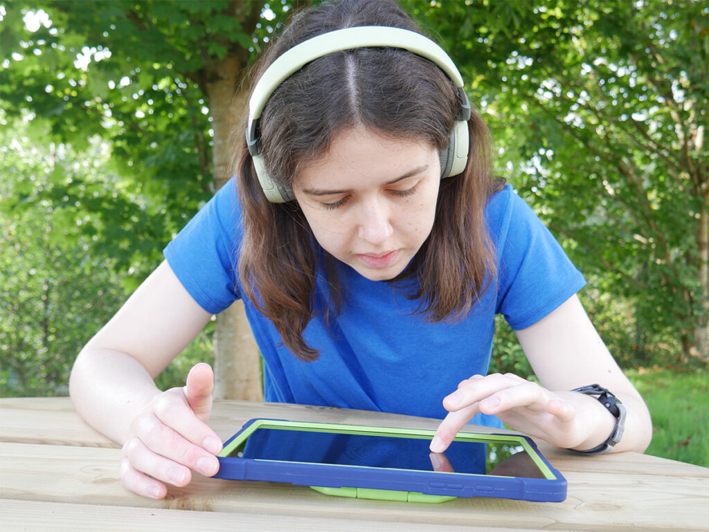 A child using Sleeping Lions with a tablet and headphones